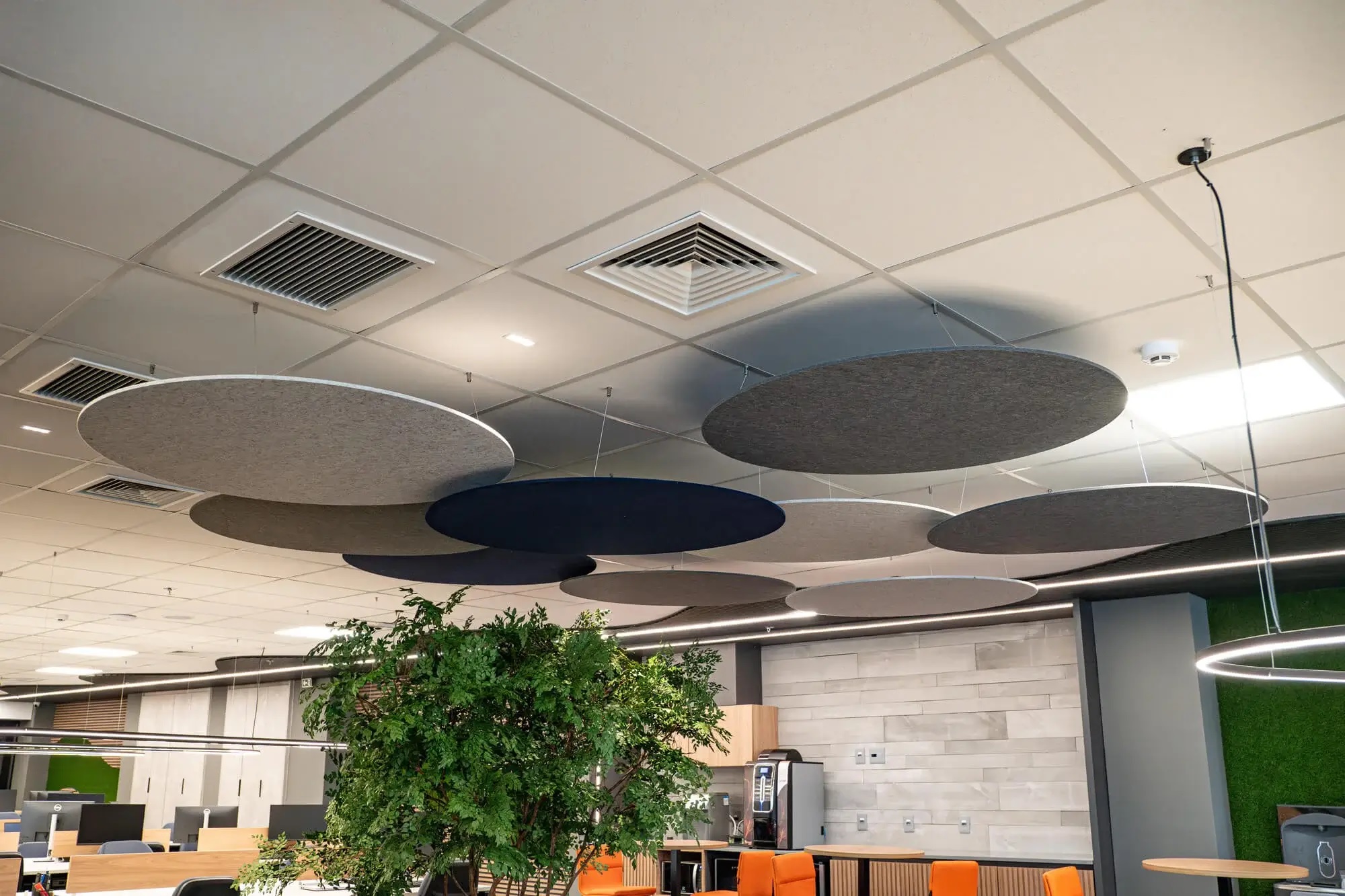 Ambiente corporativo com painéis acústicos circulares suspensos no teto