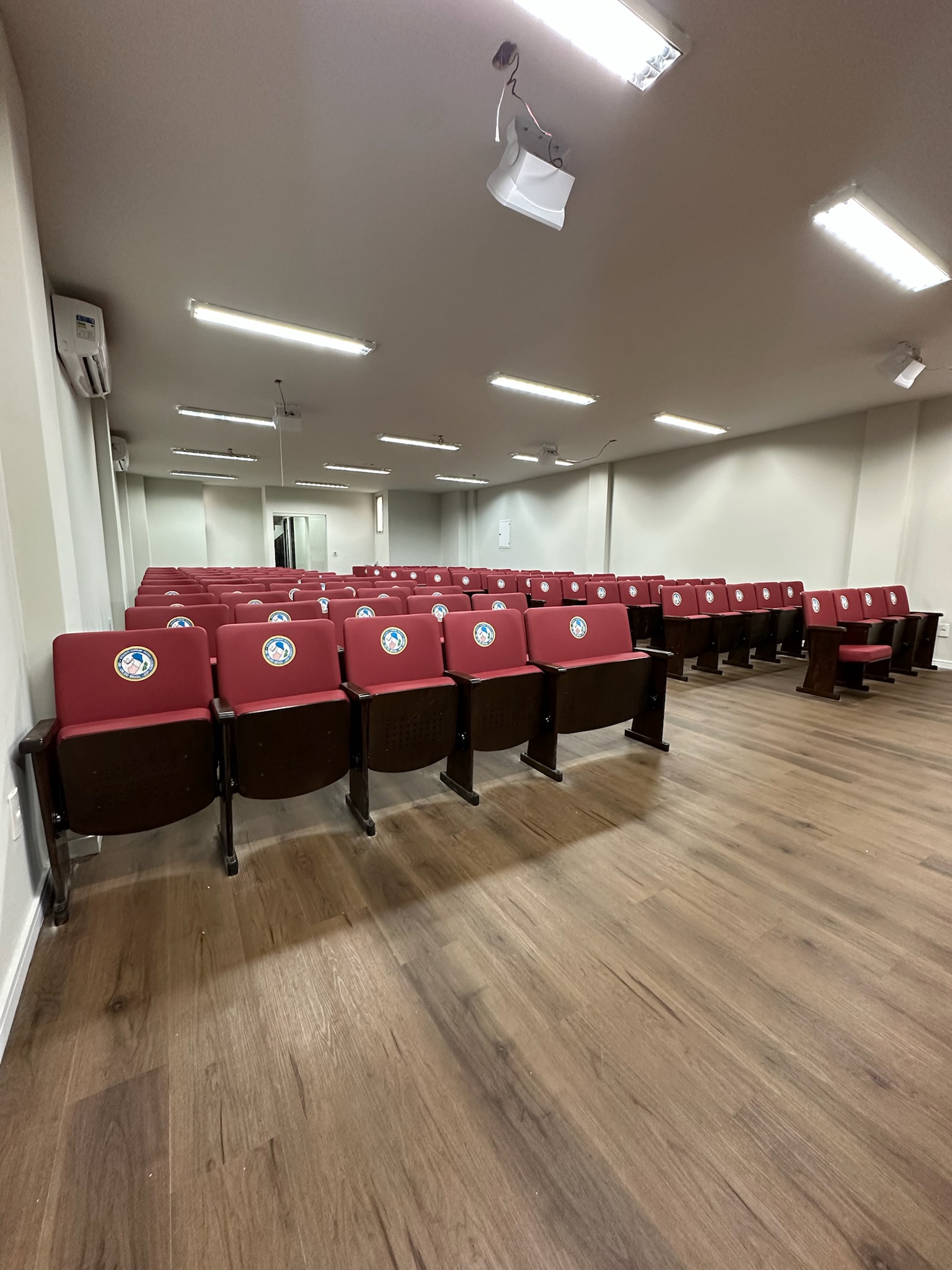Auditório institucional do GOBES com poltronas vermelhas instaladas pela Sistec
