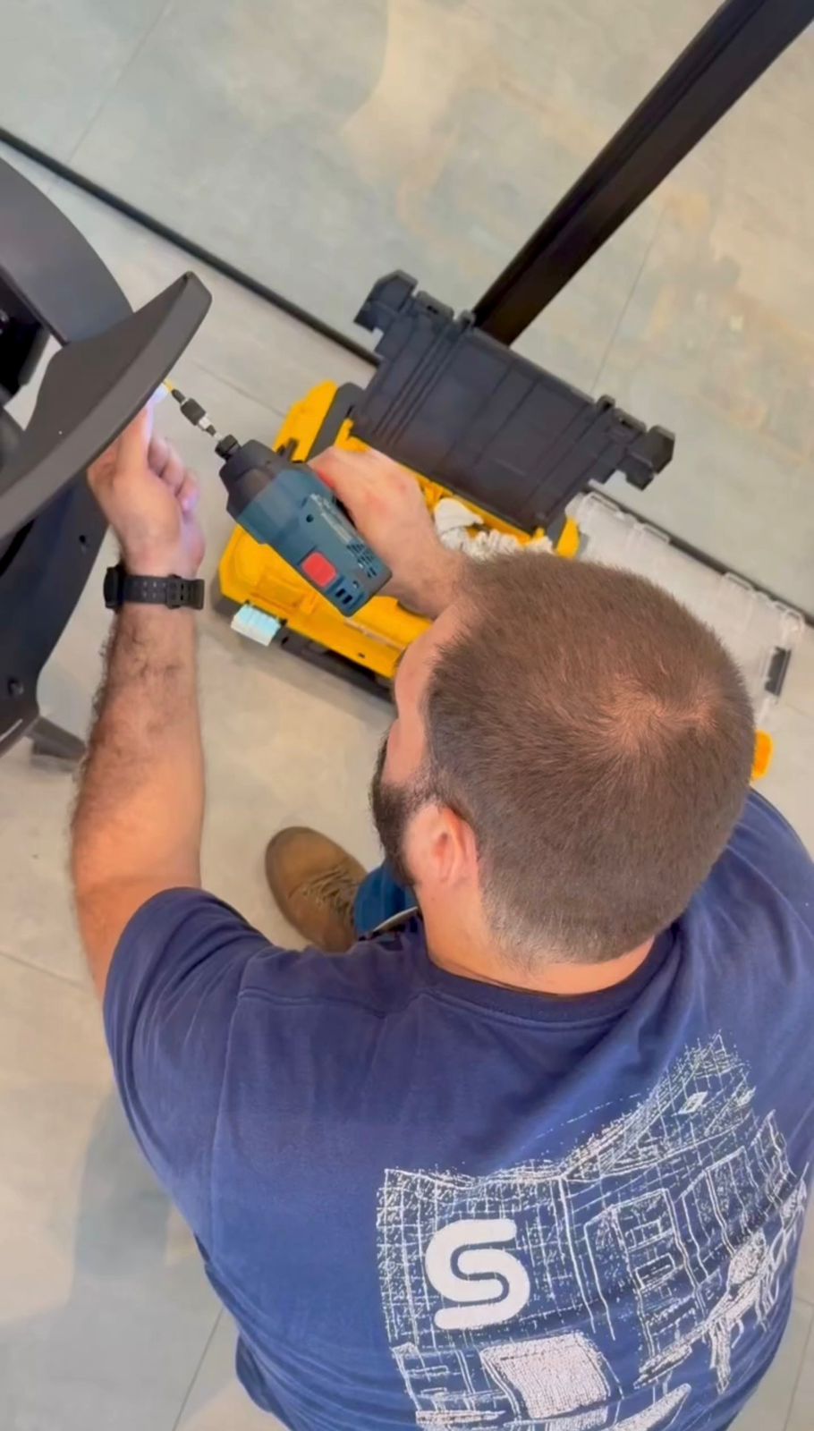 Técnico da Sistec realizando manutenção em mobiliário com ferramenta elétrica